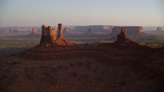 5.5K aerial stock footage of flying by buttes with more in the distance, Monument Valley, Utah, Arizona, sunset Aerial Stock Footage | AX133_147E