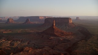 5.5K aerial stock footage of passing by buttes and mesas in famous Monument Valley, Utah, Arizona, sunset Aerial Stock Footage | AX133_152E