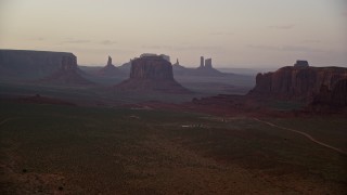 5.5K aerial stock footage of an approach to West Mitten Butte and Merrick Butte, Monument Valley, Utah, Arizona, sunset Aerial Stock Footage | AX133_189E