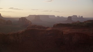 5.5K aerial stock footage approach Spearhead Mesa in hazy valley, Monument Valley, Utah, Arizona, twilight Aerial Stock Footage | AX133_201E