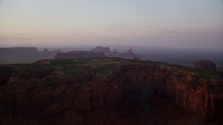 5.5K aerial stock footage of Mitchell Mesa and distant buttes, Monument Valley, Utah, Arizona, twilight Aerial Stock Footage | AX133_222