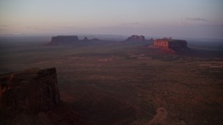 5.5K aerial stock footage of Eagle Mesa and Sentinel Mesa in Monument Valley, Utah, Arizona, twilight Aerial Stock Footage | AX133_228E