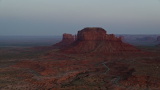 5.5K aerial stock footage of flying by buttes and hazy desert valley, Monument Valley, Utah, Arizona, twilight Aerial Stock Footage | AX134_014E