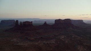 5.5K aerial stock footage of desert buttes seen through a layer of haze, Monument Valley, Utah, Arizona, twilight Aerial Stock Footage | AX134_021E