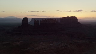 5.5K aerial aerial stock footage of passing a group of buttes in haze, Monument Valley, Utah, Arizona, twilight Aerial Stock Footage | AX134_024