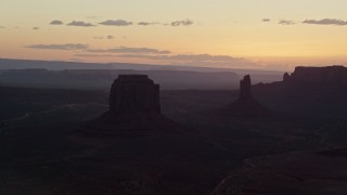 5.5K aerial stock footage of flying by Merrick Butte, West Mitten Butte in Monument Valley, Utah, Arizona, twilight Aerial Stock Footage | AX134_032