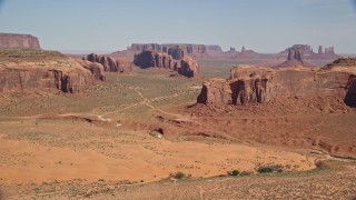 AX135_026E - 5.5K aerial stock footage approach buttes from Spearhead Mesa, Monument Valley, Utah, Arizona