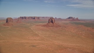 5.5K aerial stock footage of a wide view of several buttes and mesas in a desert valley, Monument Valley, Utah, Arizona Aerial Stock Footage | AX135_034E