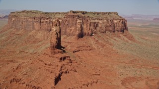 AX135_052E - 5.5K aerial stock footage of orbiting Setting Hen Butte near Eagle Mesa, Monument Valley, Utah, Arizona