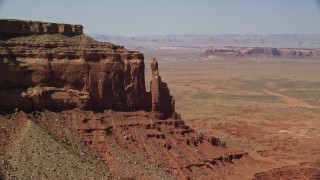 5.5K aerial stock footage of a reverse view of Eagle Rock Butte by Eagle Mesa, Monument Valley, Utah, Arizona Aerial Stock Footage | AX135_054E