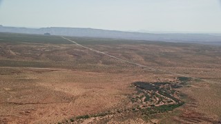 5.5K aerial stock footage of flying toward Highway 163 in desert valley, Monument Valley, Utah, Arizona Aerial Stock Footage | AX135_070E