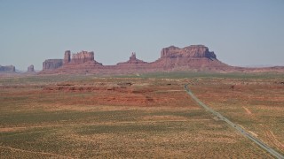 5.5K aerial stock footage of a wide view of Highway 163 leading to desert buttes, Monument Valley, Utah, Arizona Aerial Stock Footage | AX135_079E