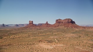 5.5K aerial stock footage of an approach to buttes across a desert valley, Monument Valley, Utah, Arizona Aerial Stock Footage | AX135_105E