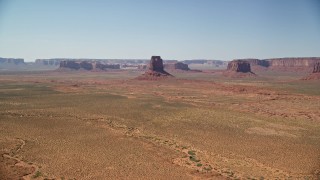 AX135_112E - 5.5K aerial stock footage of an approach to East Mitten Butte in a desert valley, Monument Valley, Utah, Arizona