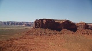 AX135_118E - 5.5K aerial stock footage orbit Spearhead Mesa in a desert valley, Monument Valley, Utah, Arizona