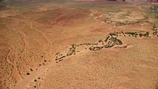 5.5K aerial stock footage of orbiting part of a desert valley with vegetation, Monument Valley, Utah, Arizona Aerial Stock Footage | AX135_121