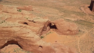 5.5K aerial stock footage of orbiting a rock arch near caves, rock formations, Monument Valley, Utah, Arizona Aerial Stock Footage | AX135_180