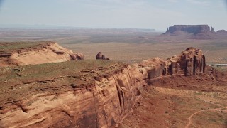 5.5K aerial stock footage of a wide view of Monument Valley buttes seen from Rock Door Mesa, Navajo Nation Reservation, Utah, Arizona Aerial Stock Footage | AX135_198E