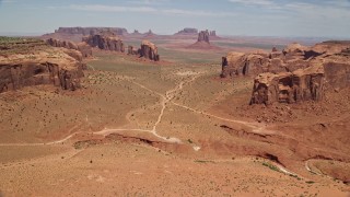 5.5K aerial stock footage of passing desert buttes and mesas to approach more landmarks in Monument Valley, Utah, Arizona Aerial Stock Footage | AX136_023E