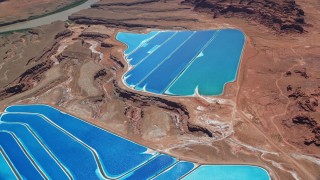 5.5K aerial stock footage of flying away from potash ponds in an arid desert valley, Moab, Utah Aerial Stock Footage | AX136_273E