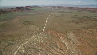 5.5K aerial stock footage of flying by Arches Scenic Drive through a desert valley, Arches National Park, Utah Aerial Stock Footage | AX137_009E