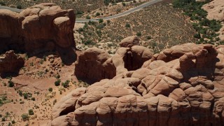 AX137_073 - 5.5K aerial stock footage of a reverse view of Double Arch and Elephant Butte at Arches National Park, Utah