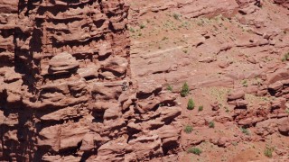 AX137_118E - 5.5K aerial stock footage of a couple of rock climbers on a rock formation at Fisher Towers, Utah