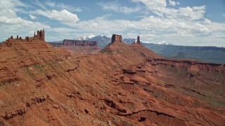 5.5K aerial stock footage of flying over a butte to approach two other buttes in Moab, Utah Aerial Stock Footage | AX137_131E