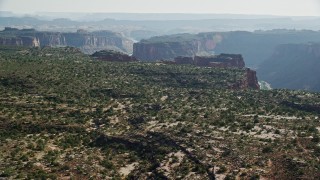 AX138_022E - 5.5K aerial stock footage fly over cliff to reveal Colorado River and Big Bend, Arches National Park, Utah