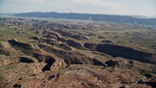 5.5K aerial stock footage approach a shallow desert canyon and rock formations in Moab, Utah Aerial Stock Footage | AX138_031