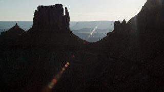 AX138_183E - 5.5K aerial stock footage fly through gap between United Nations Tablet butte and cliffs to reveal Canyonlands National Park, Utah