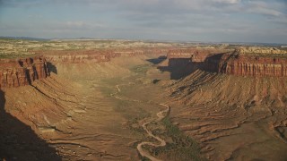 5.5K aerial stock footage of flying by dry riverbed in a wide desert canyon, Moab, Utah Aerial Stock Footage | AX138_248E