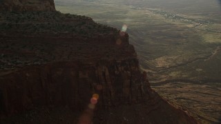 5.5K aerial stock footage of flying by steep mesa cliffs overlooking desert valley, Moab, Utah Aerial Stock Footage | AX138_252