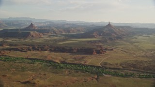 5.5K aerial stock footage slowly approach North Six-Shooter Peak, South Six-Shooter Peak in hazy valley, Moab, Utah Aerial Stock Footage | AX138_260E