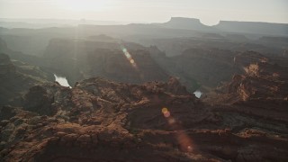 AX138_290E - 5.5K aerial stock footage orbit The Loop East in Meander Canyon and Colorado River, Canyonlands National Park, Utah, sunset