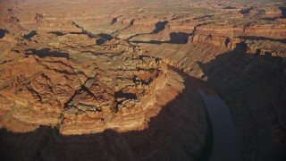 5.5K aerial stock footage of passing The Loop West in Meander Canyon and Colorado River, Canyonlands National Park, Utah, sunset Aerial Stock Footage | AX138_299