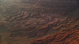 5.5K aerial stock footage of flying by rock formations and box canyons in hazy Lockhart Canyon, Moab, Utah, sunset Aerial Stock Footage | AX138_347