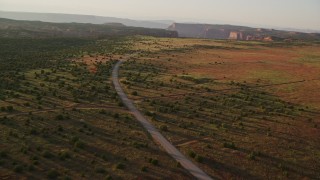 5.5K aerial stock footage of flying by Hatch Point Road and a dirt road intersection, Moab, Utah, sunset Aerial Stock Footage | AX138_354