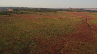 5.5K aerial stock footage of flying low over desert to approach Hatch Point Road, Moab, Utah, sunset Aerial Stock Footage | AX138_355E