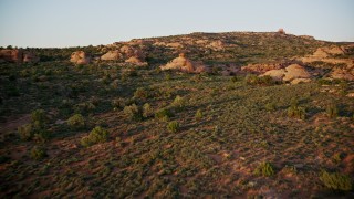 5.5K aerial stock footage of a low flight over rock formations, desert vegetation, Moab, Utah, sunset Aerial Stock Footage | AX138_387E