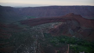 5.5K aerial stock footage of approaching rock formations near Dry Mesa cliffs, Moab, Utah, sunset Aerial Stock Footage | AX138_395E