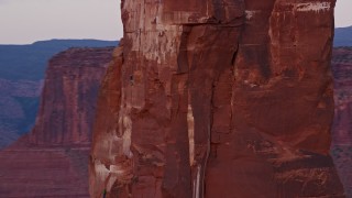 AX138_421 - 5.5K aerial stock footage of circling Castleton Tower, revealing rock climber, Moab, Utah, sunset