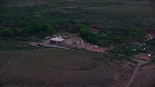 5.5K aerial stock footage of approaching a small desert museum with teepees, Moab, Utah, twilight Aerial Stock Footage | AX138_453