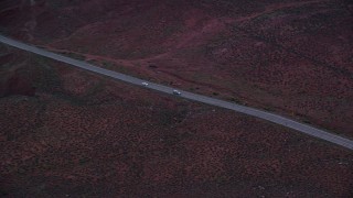 5.5K aerial stock footage of tracking sedan and SUV on State Route 128 through desert, Moab, Utah, twilight Aerial Stock Footage | AX138_454