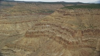 AX139_104E - 5.5K aerial stock footage of a wide view of a Cessna flying by desert mesas, Emery County, Utah