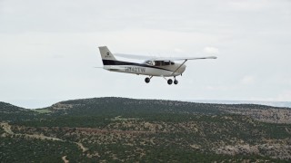 AX139_116E - 5.5K aerial stock footage reveal and then track a Cessna over desert, Emery County, Utah