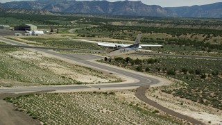 AX139_163E - 5.5K aerial stock footage of a Cessna airplane landing at airport, Buck Davis Field, Utah