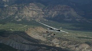 5.5K aerial stock footage of a Cessna aircraft over desert, partly cloudy, distant mountains, Carbon County, Utah Aerial Stock Footage | AX140_009E