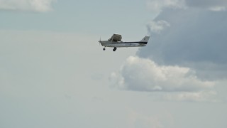 5.5K aerial stock footage of tracking a Cessna passing clouds, reveal desert mountains, Carbon County, Utah Aerial Stock Footage | AX140_030E