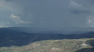 5.5K aerial stock footage of a Tecnam P2006T airplane flying by rainstorm, Wasatch Range, Utah Aerial Stock Footage | AX140_039E